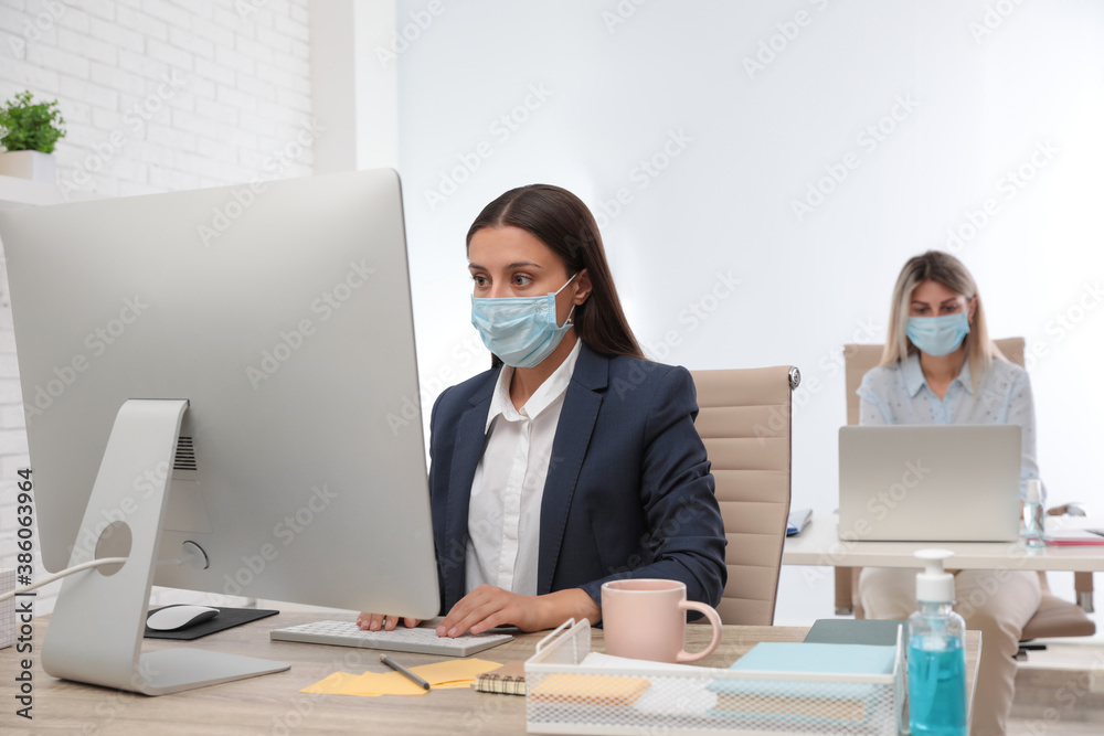 Office employees in respiratory masks at workplace Office employees in respiratory masks at workplace