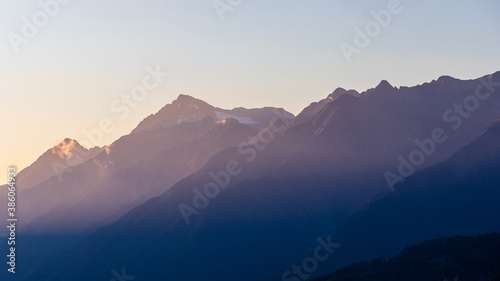 Sunset in the mountains, the rays of the setting sun on the peaks