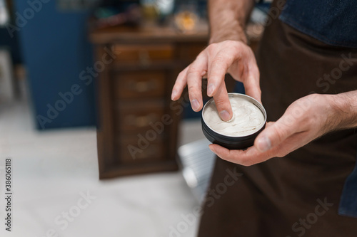 Hairdresser using pomade to hair styling photo