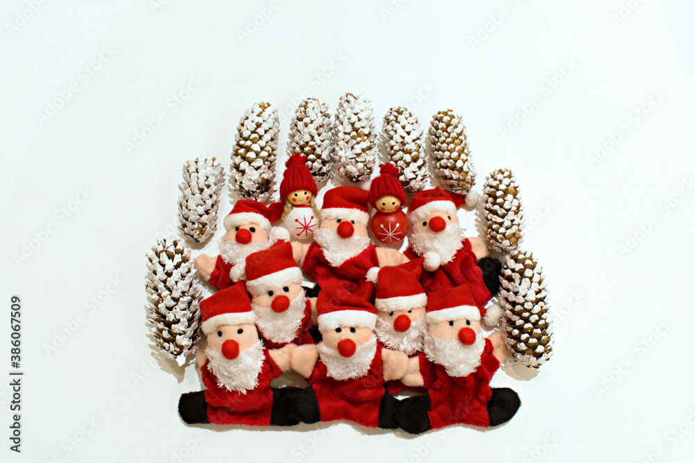 christmas toys of funny santa claus and snowmen with fir cones on a blurred white background