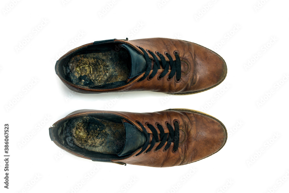 Old dirty brown leather shoes on an isolated white background. Concept, second hand, hard work, walking, worn out pair of lace-up low shoes. High quality photo Old dirty brown leather shoes on an isolated white background. Concept, second hand, hard work, walking, worn out pair of lace-up low shoes. High quality photo