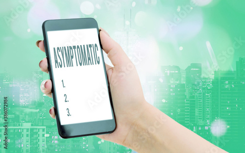 Writing note showing Asymptomatic. Business concept for a condition or an individual producing or showing no symptoms Modern gadgets white screen under colorful bokeh background photo