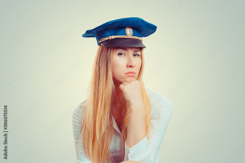 Woman in police officer hat with a suspicious face expression Woman in police officer hat with a suspicious face expression