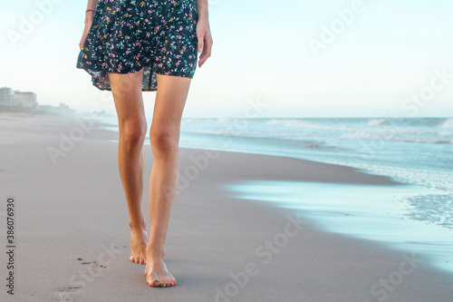 Part of the female body suffers from anorexia nervosa. Woman with anorexia take care of her health on vacation and walks along the beach. Anorexia, diet and healthy lifestyle concept