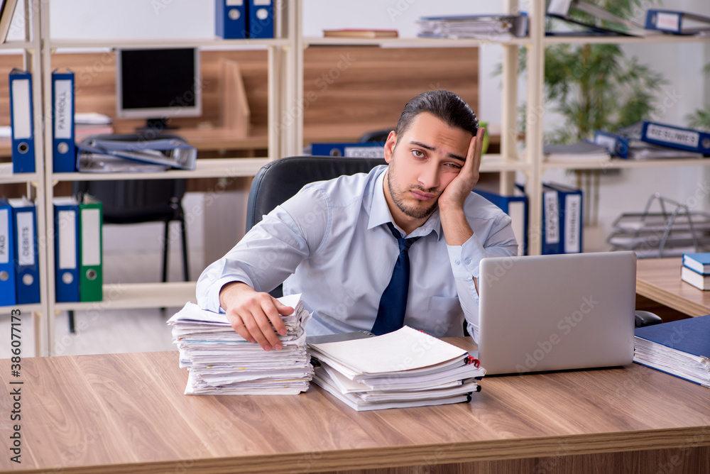 Young male employee unhappy with excessive work Young male employee unhappy with excessive work