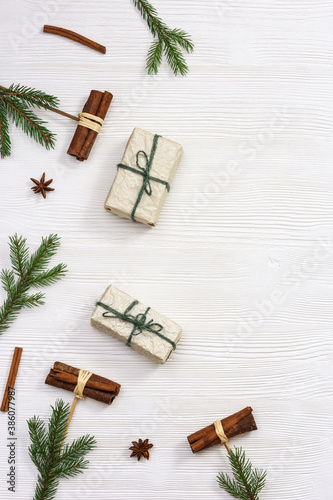 Christmas present box wrapped in kraft paper decorated natural green pine branches and cinnamon sticks