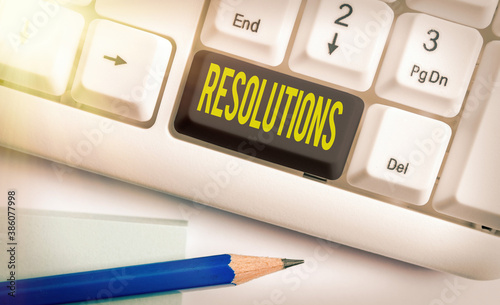 Text sign showing Resolutions. Business photo text the act of analyzing a complex notion into simpler ones Different colored keyboard key with accessories arranged on empty copy space photo