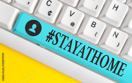 Text sign showing Hashtag Stay at home. Business photo showcasing a trending label in social media related to the coronvirus outbreak Different colored keyboard key with accessories arranged on empty photo