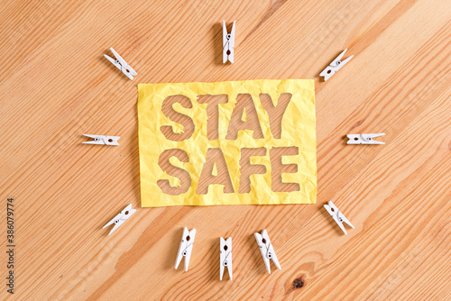 Writing note showing Stay Safe. Business concept for secure from threat of danger, harm or place to keep articles Colored clothespin papers empty reminder wooden floor background office photo