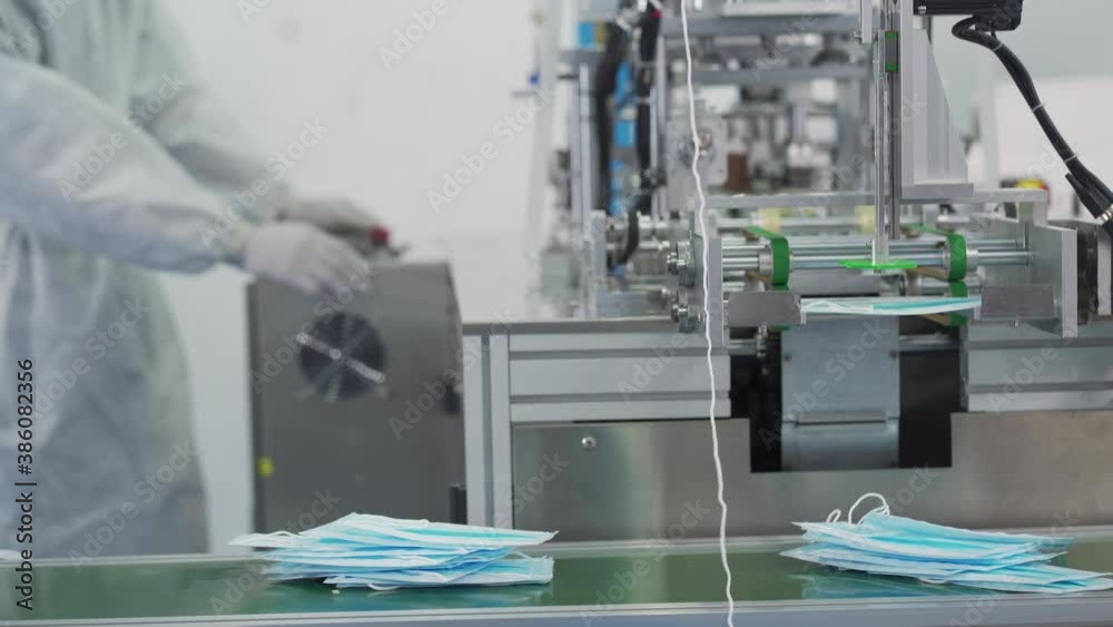Machines are working for producing masks in a sterile factory. Production of medical masks. process of manufacturing a mask