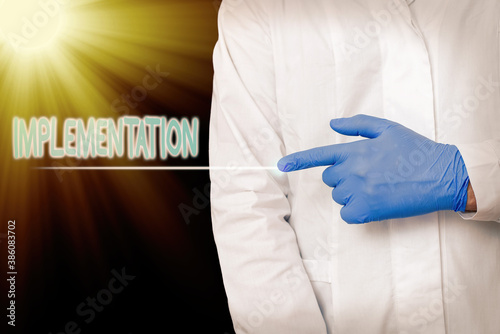 Conceptual hand writing showing Implementation. Concept meaning application of making something active or effective Displaying Sticker Paper Accessories With Medical Gloves On photo