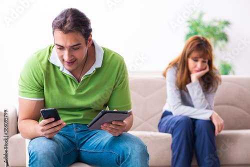 Young couple in gadget dependency concept