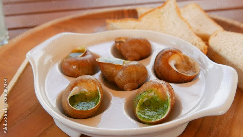 A ready made dish of snails in a sauce on a special plate in a restaurant. Expensive and healthy food. A ready made dish of snails in a sauce on a special plate in a restaurant. Expensive and healthy food.