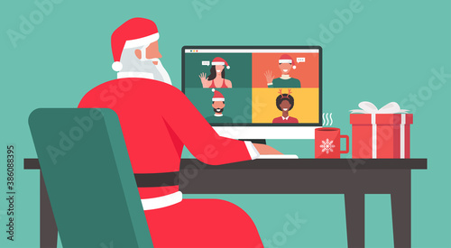 Santa Claus sitting at the desk and using a laptop video calling to people at his office on the Christmas holiday, vector flat illustration