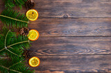 Christmas background with space for text, tree branches, dried oranges and cones on a wooden holiday table, flat lay, copy space text