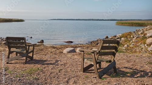 Two empty wooden chairs at a beach at Lake Vanern in Sweden