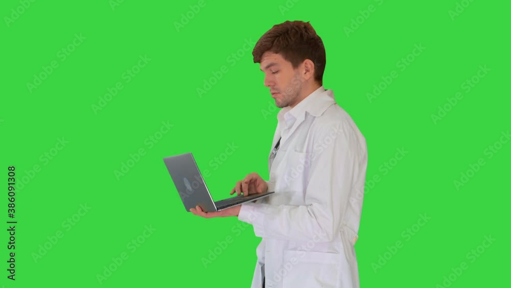 Male doctor in white coat having video conference on his laptop on a Green Screen, Chroma Key. Male doctor in white coat having video conference on his laptop on a Green Screen, Chroma Key.