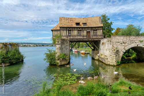 The Old mill (le vieux moulin) on the Vernon broken bridge on Seine river with swans in the foreground- Vernon, Normandy, France