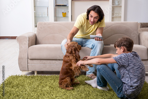 Young father and his son with cocker spaniel dog