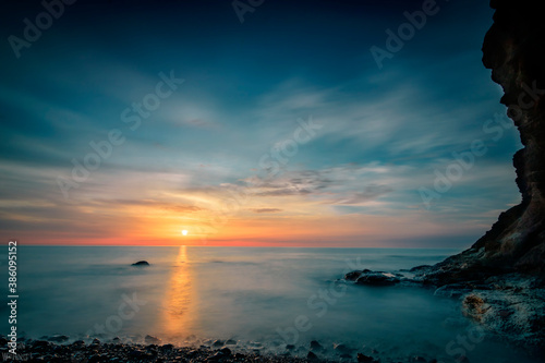 Sunrise on the ocean and beach  with rocks  great colors in the sky and in a long exposure. recorded on Fuerteventura in the Canary Islands