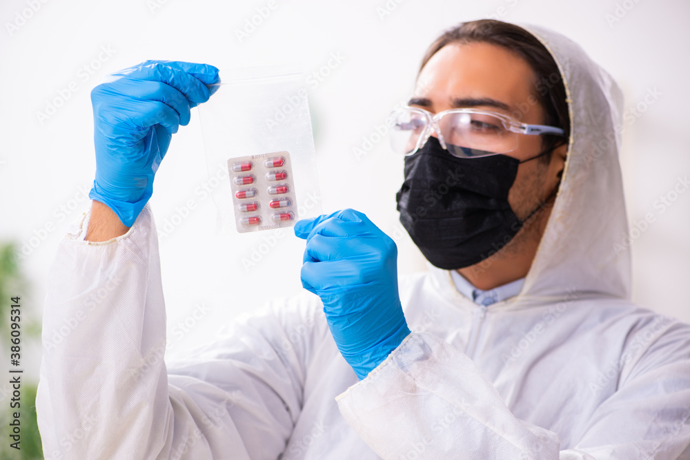 Male expert criminologist working in the lab for evidence - obrazy, fototapety, plakaty 