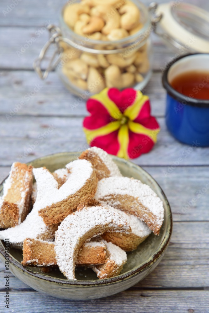 Putri Salju Kacang Mede or crescent-shaped cookies with cashew coated with powdered sugar. Popular Indonesian dessert to celebrate Eid al Fitr or Idul Fitri Putri Salju Kacang Mede or crescent-shaped cookies with cashew coated with powdered sugar. Popular Indonesian dessert to celebrate Eid al Fitr or Idul Fitri
