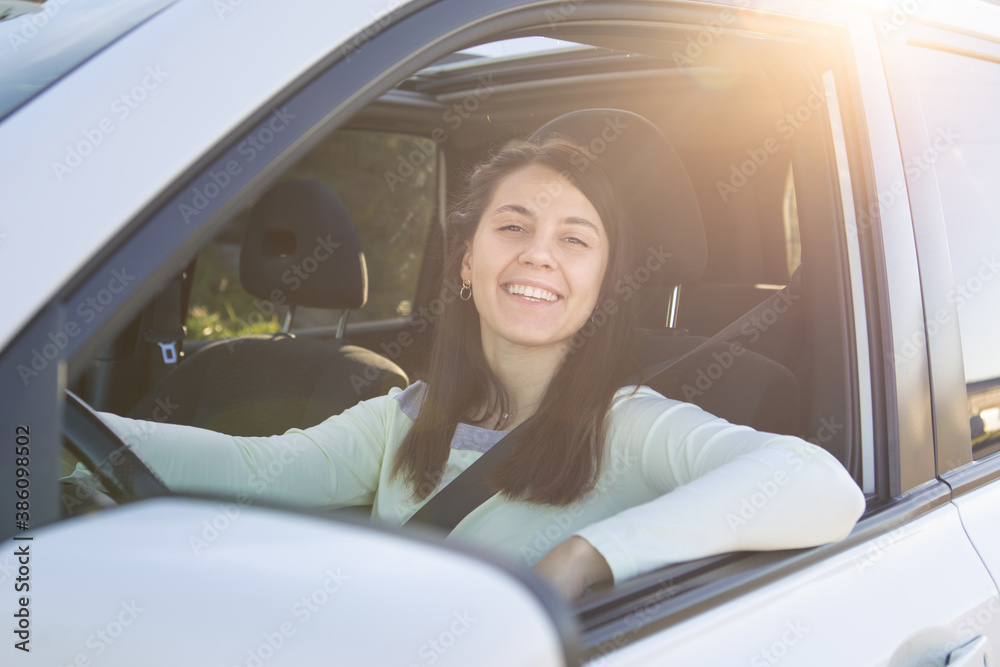 young pretty smiling woman driving car