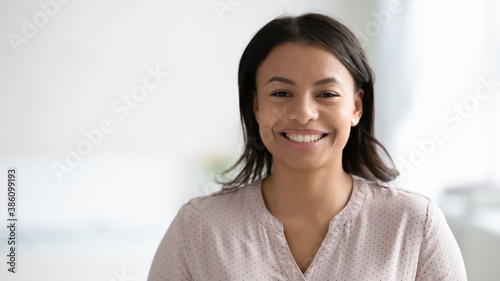 Narrow wide panoramic view headshot portrait of smiling African American young woman pose at home. Banner profile picture of happy biracial female renter or tenant look at camera. Copy space.