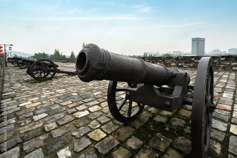 The ancient cannon is on the wall