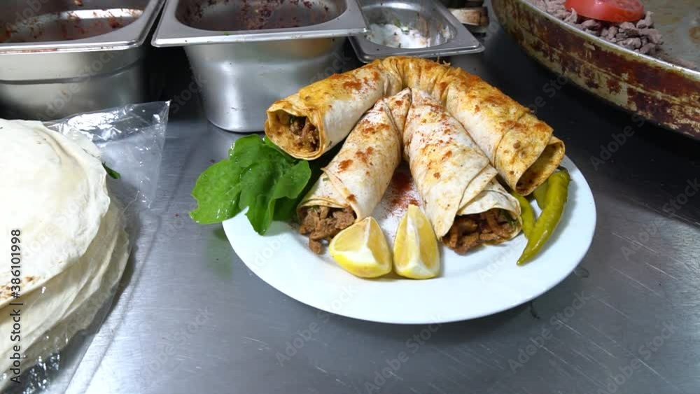 pepper is poured over the meat wrap. lemon and parsley plate pepper is poured over the meat wrap. lemon and parsley plate