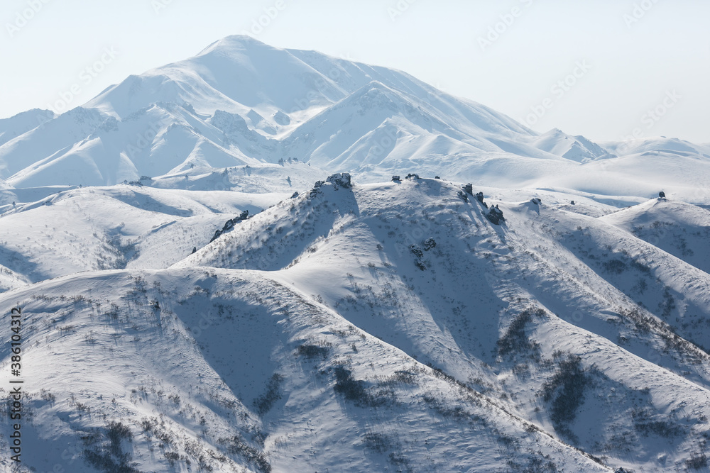 Winter mountain arctic landscape. Aerial view of snow-capped mountain peaks. Top view of the hills. The nature of Chukotka and Siberia. Travels and hikes in the Far East of Russia. Meingypilgyn Range.