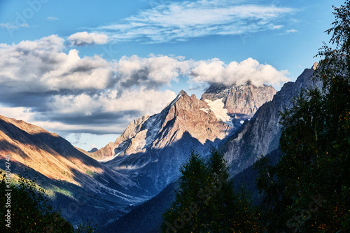 Panorama of high mountains landscape with clouds on sky. Rocks.