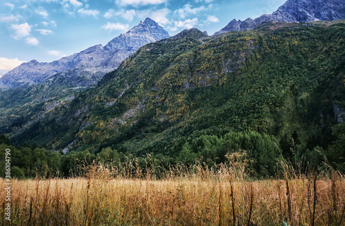 Panorama of high mountains landscape with clouds on sky. Rocks.