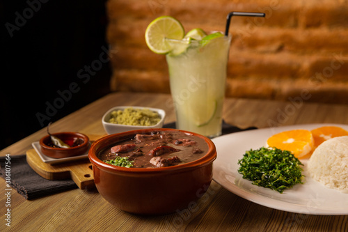 traditional Brazilian dish called feijoada, contains rice, beens, beef, pork, orange, vegetables
