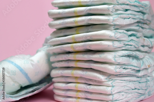 stack of diapers on a pink background, baby hygiene products
