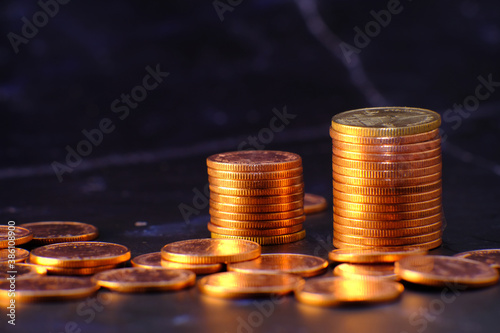 stack of golden coins on black background and advertising coins of finance and banking, increasing columns of gold coins on table