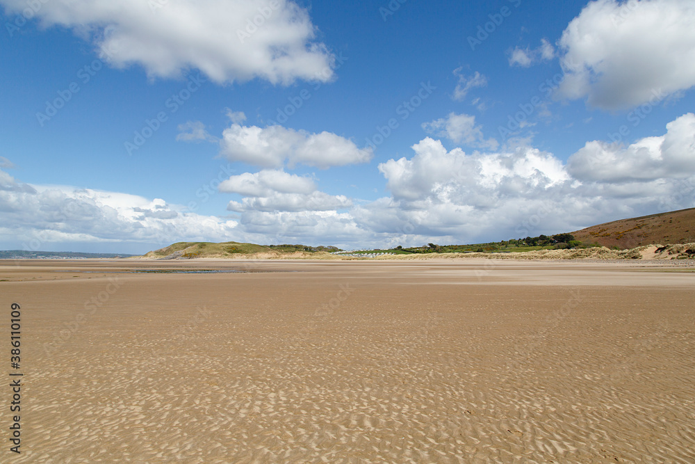 Llangennith beach is located on the west coast of Gower peninsular in Soouth Wales. Beautiful clouds at low tide with copy space. 
