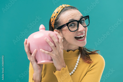 Happy woman holding a full money box photo