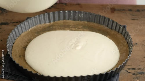 Greek cheese pie. Woman prepares a pie with feta cheese. Black background.