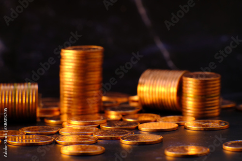 stack of golden coins on black background and advertising coins of finance and banking, increasing columns of gold coins on table