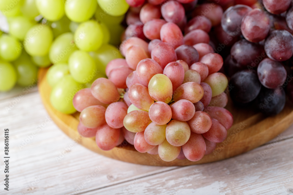 Various color bunch fresh grapes on wooden board. Various color bunch fresh grapes on wooden board.