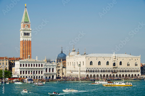 Panoramic scenic view of Venice Venezia skyline with bell towers, old historic buildings palazzi houses, basilica churches and San Marco tower and Doge palace and maritime traffic on Giudecca Canale photo