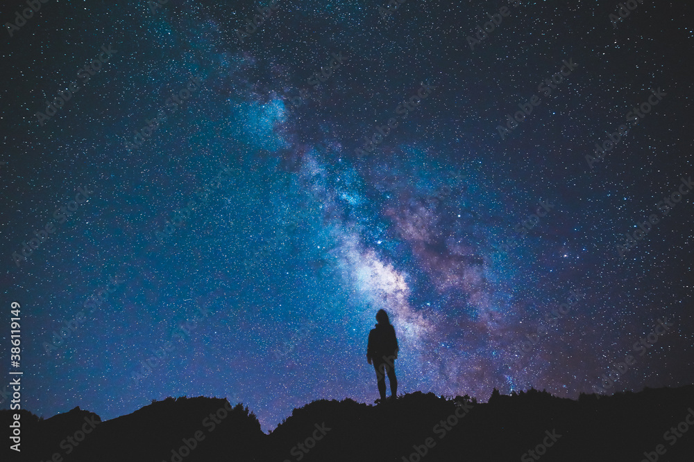 Silhouette of girl / woman standing on the hill.  Stargazing at Oahu island, Hawaii. Starry night sky, Milky Way galaxy astrophotography.