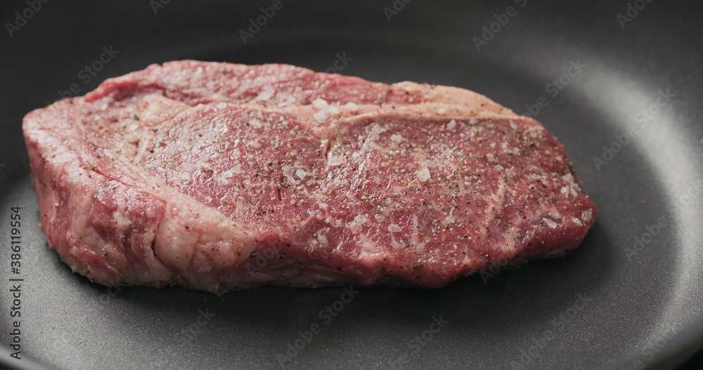Closeup shot of ribeye steak frying on non stick pan