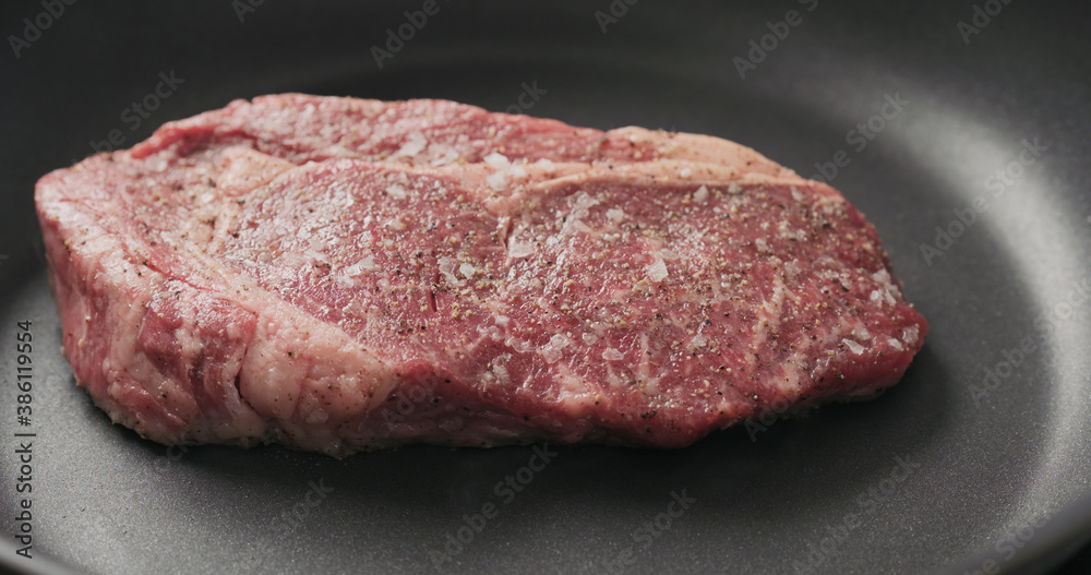 Closeup shot of ribeye steak frying on non stick pan Closeup shot of ribeye steak frying on non stick pan