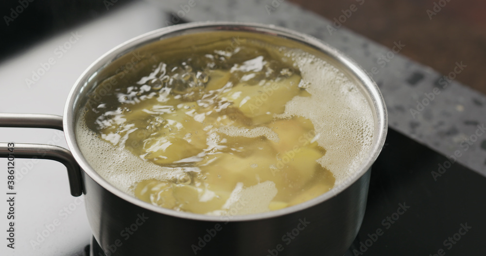 potato wedges boiling in saucepan potato wedges boiling in saucepan