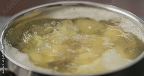 potato wedges boiling in saucepan