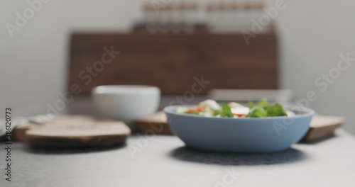 Blurred backgroiund of bowl with salad on concrete countertop