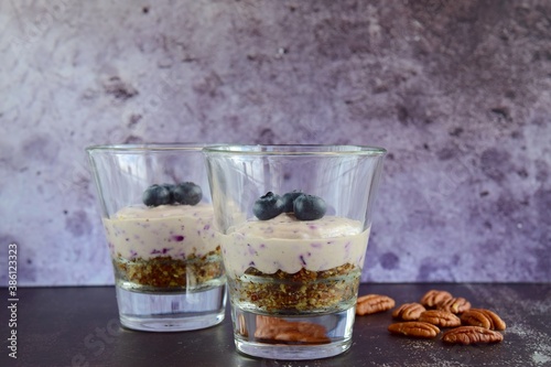 Vegan blueberry cheesecake with pecan date crust served in glasses