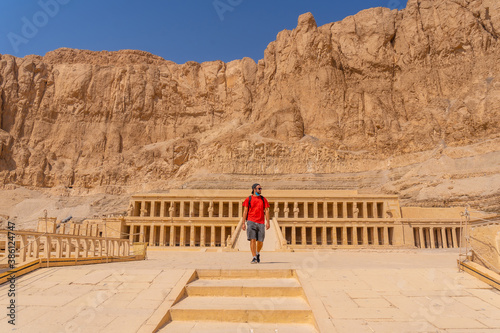 A young woman visiting the Mortuary Temple of Hatshepsut without people on her return from tourism in Luxor after the coronavirua pandemic, Egypt